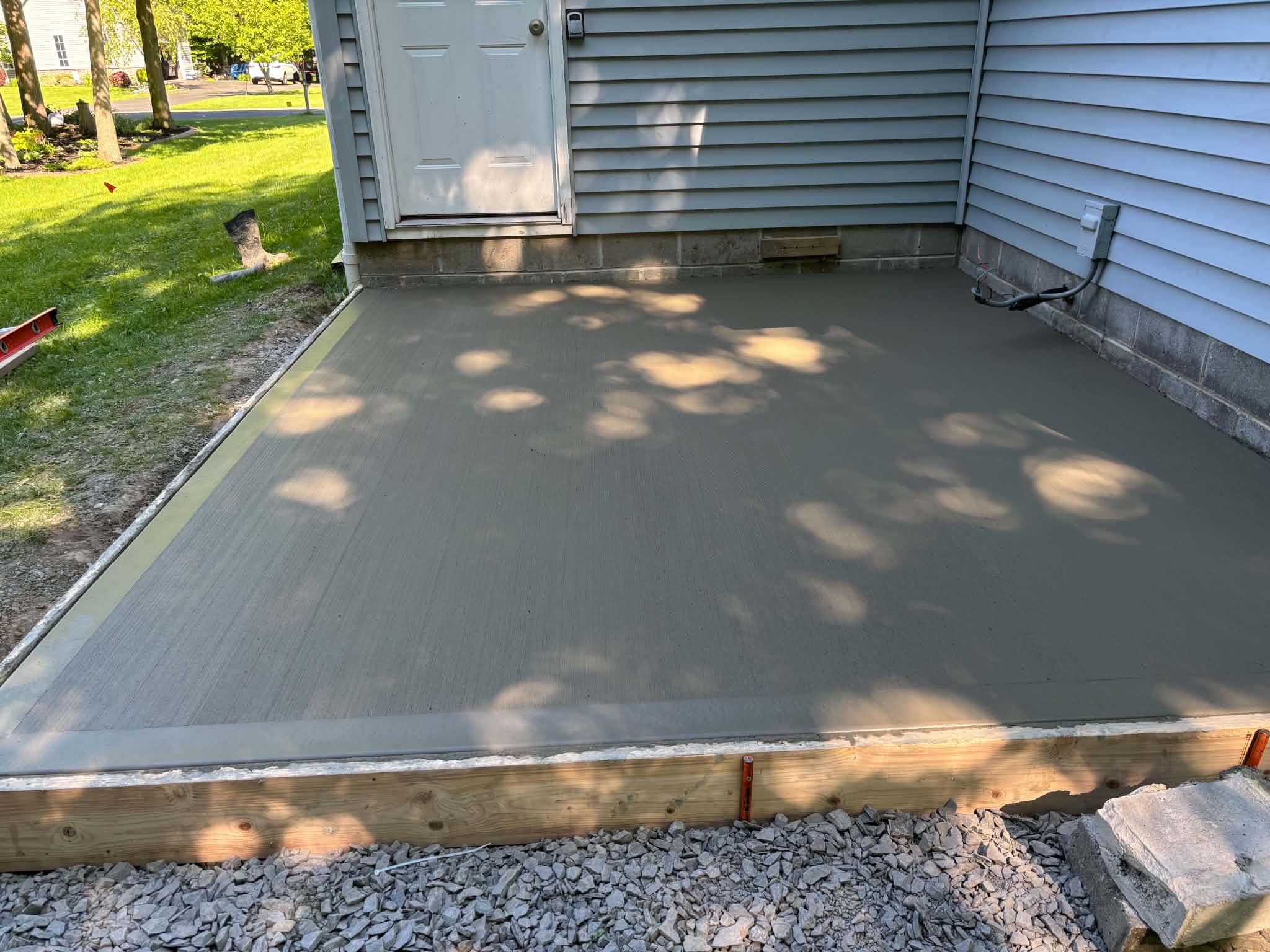 Finished broom-finish concrete pad — Keystone Masonry concrete patio installation Rochester NY, control joints cut, texture applied