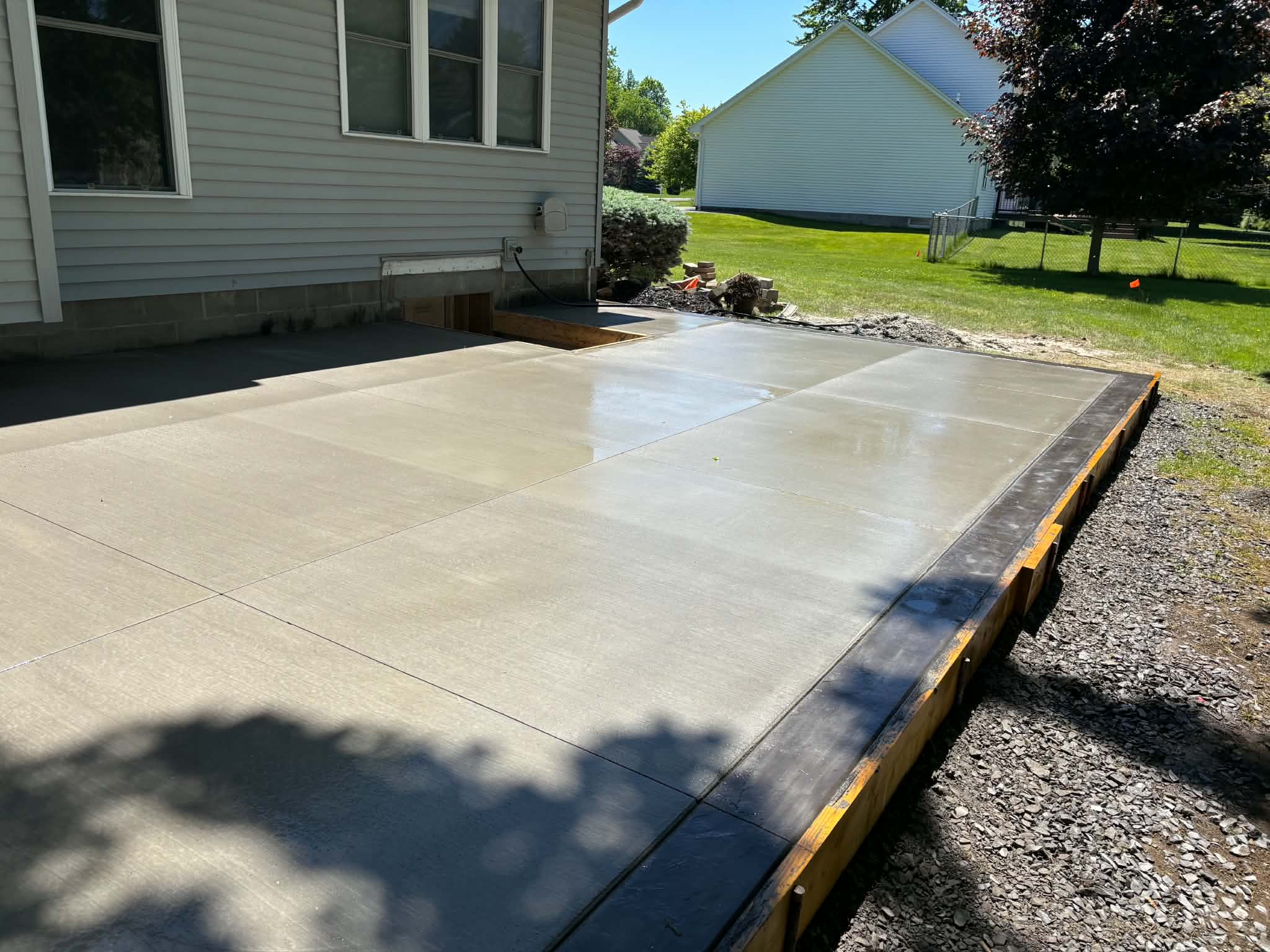 Hand-troweled smooth picture-frame perimeter border on large concrete patio — Keystone Masonry Webster NY, high-contrast architectural finish