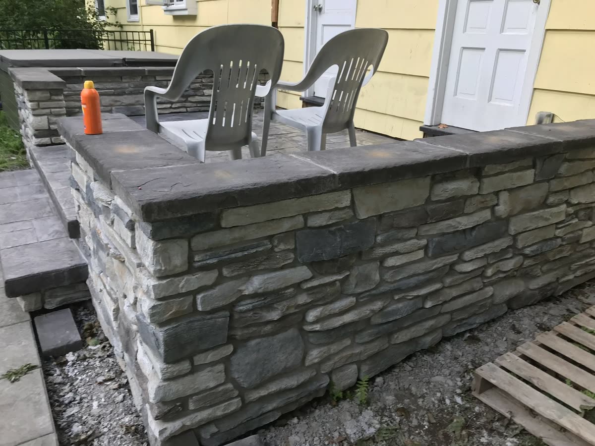 Cultured stone veneer with stamped patio cap