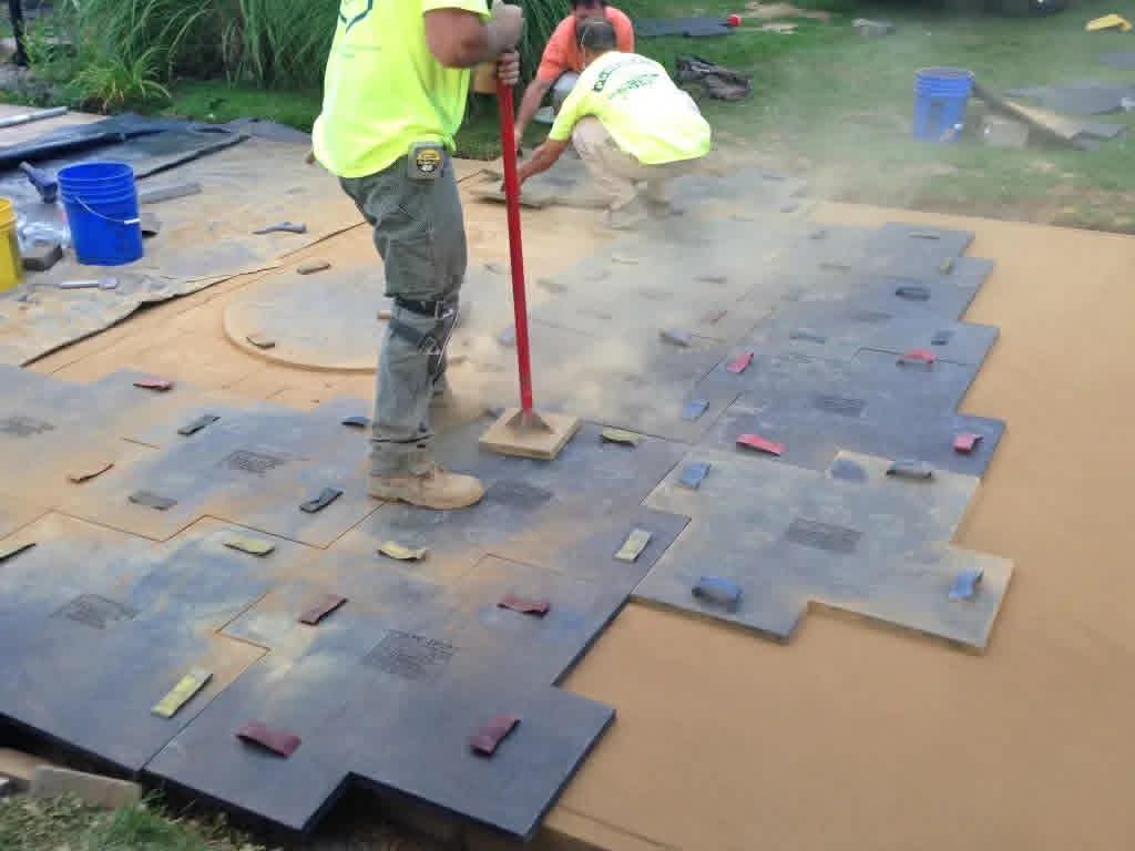 Don and crew pressing stamping mats into fresh concrete during patio installation — Keystone Masonry Rochester NY